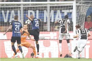  ?? — Gambar Reuters ?? GEGAR JARING: Higuain (kanan) menanduk masuk gol kemenangan Juve pada minit akhir permainan ketika beraksi pada perlawanan liga di San Siro, Milan Sabtu lepas.