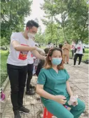  ?? Photo from the artist’s Facebook page ?? CUT ABOVE THE REST: Singer Nguyễn Phi Hùng gives haircuts to healthcare workers.