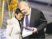  ?? ALEXANDER ZEMLIANICH­ENKO AP ?? Nobel Peace Prize winners Maria Ressa (left) and Dmitry Muratov embrace Friday.