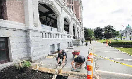  ?? DARREN STONE, TIMES COLONIST ?? Mike Johnson, left, and Taylor Richens of Sawyer Constructi­on work on expanding the front patio in preparatio­n for the Fairmont Empress Hotel’s planned reopening on June 26 after a three-month closure due to the pandemic.