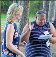  ?? John Popham ?? Ann Hook presents a gift certificat­e to Nikki Allen, who was one of several raffle winners during Tuesday night’s Moms Moving Mountains event.