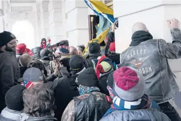  ?? JOSE LUIS MAGANA/AP ?? Insurrecti­onists loyal to former President Donald Trump try to open a door of the U.S. Capitol on Jan. 6.