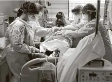  ??  ?? A team of nurses works to turn over a patient to increase oxygen flowWednes­day in the COVID-19 ICU unit at University Medical Center in Lubbock.