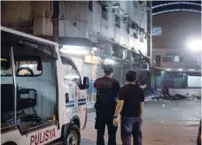  ?? — AFP ?? Police officers take position after an explosion in Quiapo in Manila on Saturday.
