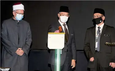 ?? — Bernama ?? Making an impact: Muhyiddin (centre) launching the Nusantara Syariah Judiciary and Legal Conference. Looking on is Zulkifli (left) and Mohd Na’im,