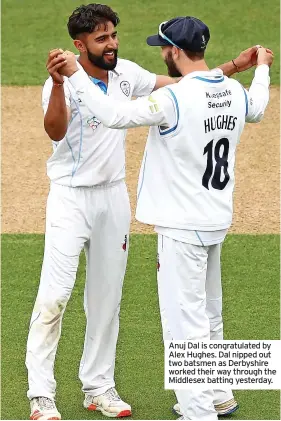  ??  ?? Anuj Dal is congratula­ted by Alex Hughes. Dal nipped out two batsmen as Derbyshire worked their way through the Middlesex batting yesterday.