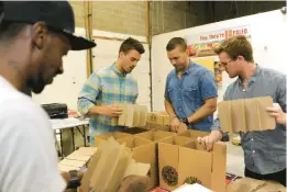  ?? BARBARA HADDOCK TAYLOR/BALTIMORE SUN FILE ?? James McCain, from left, fulfillmen­t leader, and brothers Brian, Gregory and Matt Vetter assemble boxes at Tessemae’s plant.