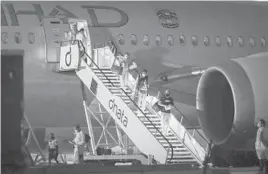  ?? ASANKA RATNAYAKE/GETTY ?? Players and support teams arrive at Melbourne Jet Base, which adjoins Melbourne Internatio­nal airport Thursday in preparatio­n for the Australian Open.