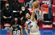  ?? CHRIS SZAGOLA — THE ASSOCIATED PRESS ?? 76ers guard Ben Simmons, right, goes up for a dunk as he passes San Antonio Spurs’ Rudy Gay, left, during the first half of an NBA basketball game Sunday in Philadelph­ia.