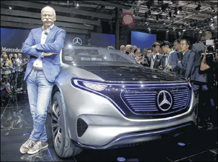  ?? MICHEL EULER / AP ?? Diamler CEO Dieter Zetsche stands next to the Mercedes EQ concept car at the Paris Auto Show on Thursday. Zetsche said the company aims to have 10 electric models by 2025.