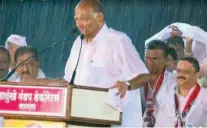  ??  ?? A drenched Pawar delivers an impassione­d speech at a rally.