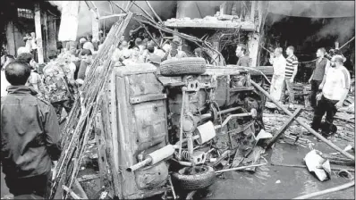  ?? AP/SANA ?? Syrian residents and security forces gather Monday near a car that was destroyed by a car bomb in Damascus, Syria, in this photo released by the Syrian official news agency SANA.