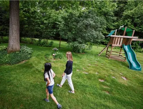  ?? SUZANNE KREITER/GLOBE STAFF ?? A Westminste­r homeowner and her daughter walked in their backyard near their water well in 2022. The well water is contaminat­ed with PFAS chemicals.