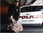  ?? BILL UHRICH — MEDIANEWS GROUP ?? Exeter Township Police Sgt. Sean Fullerton examines rocks that were placed in the traveling lanes of Route 422 in Exeter Township.