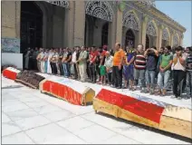  ?? KHALID MOHAMMED/ THE ASSOCIATED PRESS ?? Mourners pray during a mass funeral Thursday at a Baghdad mosque for four men killed when a bomb in a parked car blew up Wednesday outside a coffee shop in a largely Sunni neighborho­od.