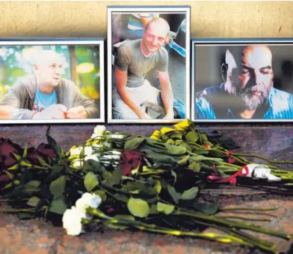  ?? AP ?? Flores y retratos fueron colocados en el edificio del Sindicato de Periodista­s de Rusia, en Moscú, este 1.° de agosto del 2018, en memoria de los tres reporteros asesinados en la República Centroafri­cana.