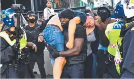  ??  ?? HE AIN’T HEAVY: Black Lives Matter supporter Patrick Hutchinson carries an injured Far-Right protester to safety.