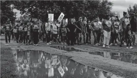  ?? Sam Owens/staff photograph­er ?? People hold up pictures of Eliahna Torres as they march through Hillcrest Memorial Cemetery in Uvalde on Nov. 2 to visit the gravesites of Robb Elementary massacre victims.