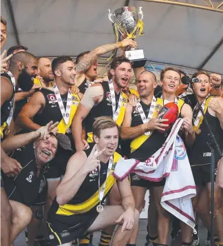  ?? Picture: JERAD WILLIAMS ?? Labrador players celebrate after their QAFL grand final win last year. TERRY WILSON