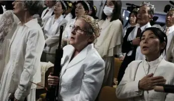  ?? SPENCER PLATT/GETTY IMAGES ?? Worshipper holds an AR-15 rifle during a ceremony at the World Peace and Unificatio­n Sanctuary in Pennsylvan­ia.