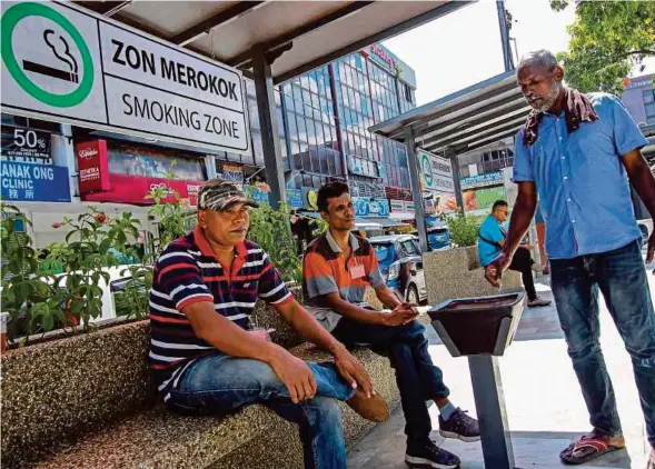  ?? PIC BY AIZUDDIN SAAD ?? Smokers at a designated smoking area in Santai @ Ampang in Kuala Lumpur yesterday.