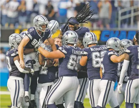  ?? GREGORY BULL/ASSOCIATED PRESS ?? Cowboys kicker Greg Zuerlein, second from left, is lifted by teammates after making the game-winning field goal as time expired during the end of Sunday’s game against the Chargers Inglewood, Calif. The Cowboys won 20-17.