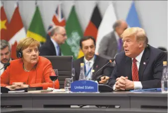  ?? AFP / Getty Images ?? German Chancellor Angela Merkel (left) listens to President Trump during a plenary session of the Group of 20 summit in Buenos Aires. The next G-20 summit will be held in Osaka, Japan.