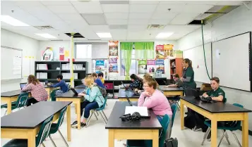  ?? Ana Ramirez/
Austin American-Statesman via AP ?? aboveTwo water diverters drip into trash cans Jan. 15 at the Rockport-Fulton Middle School while students have class in Rockport, Texas. Air-conditioni­ng units were torn off the rooftops of schools at the Aransas County school district during Hurricane Harvey, leaving holes in the roofs. leftConstr­uction crews plaster the walls of the Odyssey After School Enrichment Program Jan. 16 in Rockport. The center was damaged during Harvey.