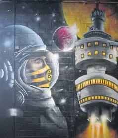  ?? AFP ?? An astronaut painted in the colours of Dortmund on a wall in Signal Iduna Park.