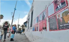  ?? AFP ?? A man looks at posters of Tunisian presidenti­al candidates in the capital Tunis.