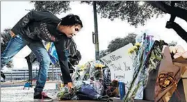  ?? ERIC GAY/AP ?? Faith Reyna leaves flowers Monday at a memorial for a slain San Antonio officer.