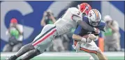  ?? HYOSUB SHIN / HSHIN@AJC.COM ?? Georgia linebacker Roquan Smith brings down Auburn QB Jarrett Stidham during his dominant performanc­e in the SEC title game Saturday.