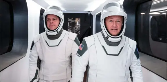  ?? AP PHOTO COURTESY SPACEX ?? In this Jan. 17, 2020 photo made available by Spacex, NASA astronauts Bob Behnken, left, and Doug Hurley, wearing Spacex spacesuits, walk through the Crew Access Arm connecting the launch tower to the Spacex Crew Dragon spacecraft during a dress rehearsal at NASA’S Kennedy Space Center in Cape Canaveral, Fla. For their May 27 mission, Hurley will be in charge of launch and landing and Behnken will oversee rendezvous and docking at the Internatio­nal Space Station.