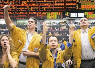  ?? JOHN GRESS / REUTERS ?? Clerks at the Chicago Mercantile Exchange react to the news that the Fed raised its key rate yesterday.