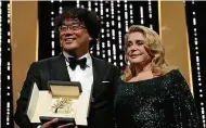  ?? FOTO: V. LE CAER/DPA ?? Regisseur Kang-Ho Song (l.) steht neben Schauspiel­erin Catherine Deneuve und hält die „Goldene Palme“.