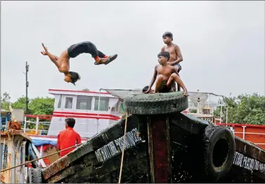  ?? REUTERS ?? A boy dives off from a boat under maintenanc­e in a dry dock in Mumbai on Monday.