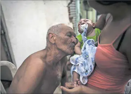  ?? Photos: Reuters/Nacho Doce/Reuters ?? Lifeline: A man kisses his two-month-old great-grandson, born with microcepha­ly. As Brazil reels from Zika, the story of Ana Carolina Cáceres (below) is a source of inspiratio­n.