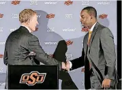  ?? THE OKLAHOMAN] [PHOTO BY STEVE GOOCH, ?? OSU athletic director Mike Holder, left, shakes hands with basketball coach Mike Boynton during Boynton’s introducto­ry news conference in March 2017.