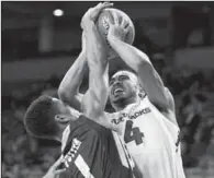  ??  ?? IN YOUR FACE: Arkansas’ Jabril Durham (4) shoots a basket over Charleston Southern’s Armel Potter (1) in the first half of the Razorbacks’ 93-75 victory Friday night at Walton Arena in Fayettevil­le. The 2-1 Hogs return to action Thursday against...