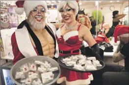  ?? Paul Kuroda For The Times ?? SANTA’S HELPERS Mudd and Lisa Frankenste­in hold a tray of the drug overdose antidote Narcan to give to guests at the San Francisco club Oasis last month.