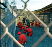  ?? (AP/U.S. Navy/file/Shane T. McCoy) ?? Taliban and al-Qaida detainees in orange jumpsuits sit in a holding area at the Guantanamo Bay detention center in January 2002. Military officials soon regretted releasing the photo as reports of brutal treatment came out.