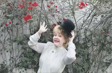  ?? Brian van der Brug Los Angeles Times ?? DEBBIE REYNOLDS strikes a showbiz pose with Charlie Chaplin’s hat, part of her memorabili­a collection.