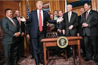  ?? Brendan Smialowski / AFP / Getty Images ?? President Donald Trump reacts to a question about the 9th U.S. Circuit Court of Appeal on Wednesday after signing an executive order to review the Antiquitie­s Act at the Interior Department.