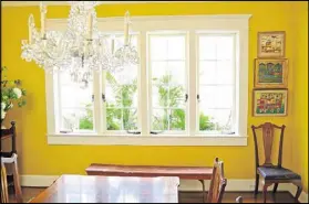  ??  ?? The dining room windows are among the favorite architectu­ral elements in Jill Helmer’s home, particular­ly when flowers are in full bloom in the window box. A custom mix by Pratt &amp; Lambert gives the room a cheerful tone.