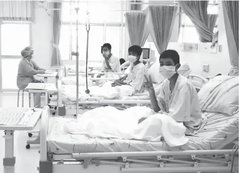  ?? THAI GOVERNMENT PUBLIC RELATIONS DEPARTMENT AND GOVERNMENT SPOKESMAN BUREAU / AFP / GETTY IMAGES ?? Members of the Wild Boars football team wave to the cameras in their hospital room in Chiang Rai, Thailand. The 12 boys rescued from a Thai cave were passed “sleeping” on stretchers through the passageway­s, a former Thai Navy SEAL said Wednesday, as...