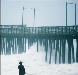  ?? AP/The Virginian-Pilot/L. TODD SPENCER ?? Lucille Rang, who is originally from Canada but moved to Virginia Beach recently, looks at the waves at a fishing pier in Virginia Beach, Va., as the remnants of Tropical Storm Hermine makes its way up the coast. Forecaster­s said the system could...