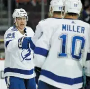  ?? TIM MIHALEK — THE ASSOCIATED PRESS ?? The Tampa Bay Lightning’s Brayden Point, left, skates towards Steven Stamkos and J.T. Miller to celebrate his goal during the third period of Saturday’s game against the Philadelph­ia Flyers. The Lightning won 6-5 in overtime.