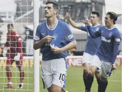  ??  ?? 0 Boyhood supporter Graham Dorrans points to the club crest after firing Rangers ahead from the penalty spot against Motherwell.