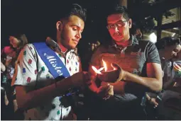  ?? LOREN TOWNSLEY/ THE REPUBLIC ?? At Sunday’s LGBT equality rally, Javier Flores (left) and Edward Castro participat­e in a vigil to honor the victims of the Pulse nightclub shooting, which occurred a year ago today.