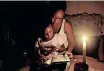  ?? | BONGIWE MCHUNU ?? SANELISIWE reads a bedtime story to her daughter Nandi, 2, by candleligh­t as Eskom load shedding hits their area in Newlands East, Durban.